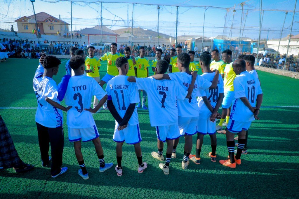 Two football teams on the pitch during a sponsored match